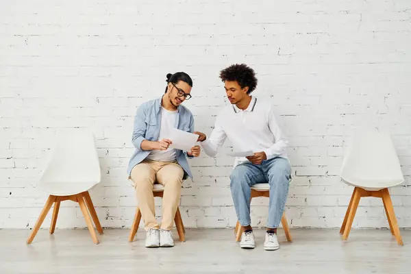 Two individuals engaged in a lively conversation while seated on chairs. — Stock Photo