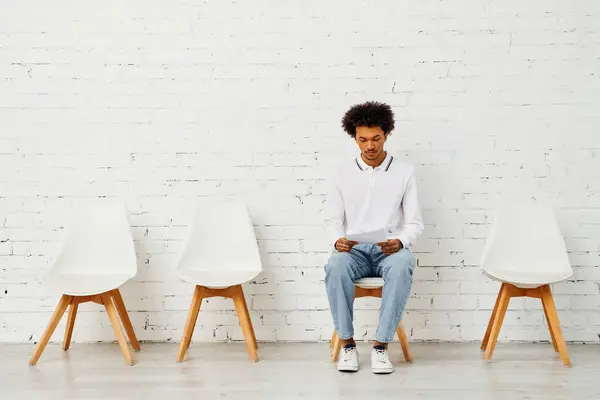 Man surrounded by white chairs in an artistic display of solitude. — Stock Photo