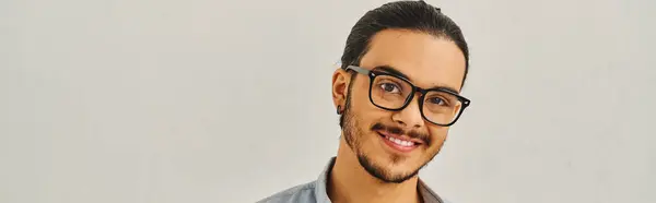 A man with glasses smiling against white backdrop. — Stock Photo