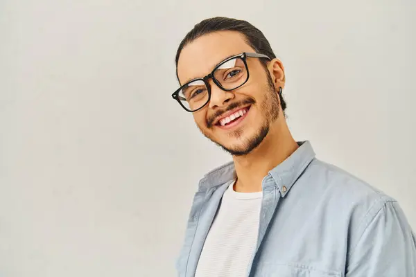 A man with glasses smiling brightly in a blue shirt. — Stock Photo
