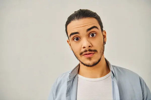 Um homem fazendo um rosto engraçado contra um fundo branco. — Fotografia de Stock