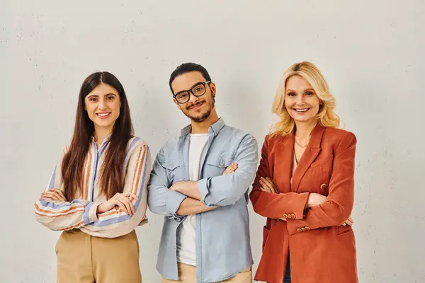 Three professionals posing confidently in front of white backdrop. — Stock Photo