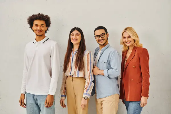 Group of attractive people posing stylishly in front of a sleek gray wall. — Stock Photo
