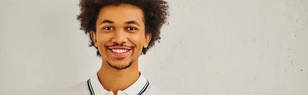 Smiling man with curly hair in front of white background. — Stock Photo