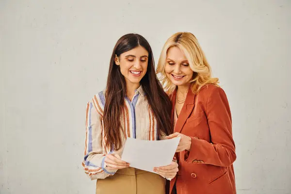 Dos mujeres estudian intensamente un trabajo juntas mientras están en la entrevista de trabajo. — Stock Photo