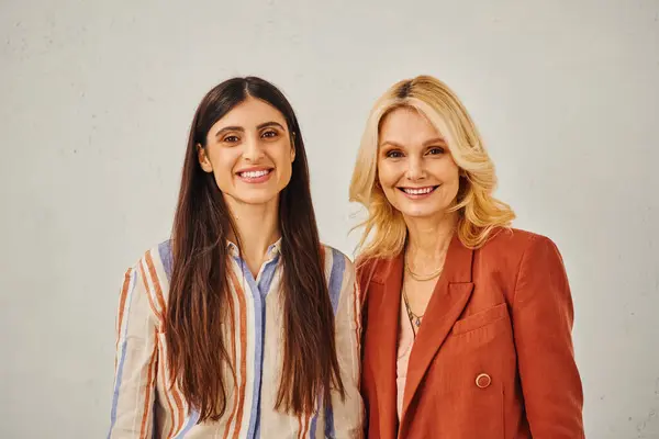 Two women striking graceful poses against a white backdrop. — Stock Photo