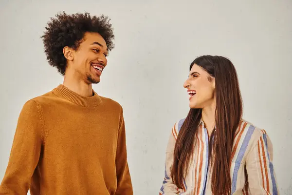 L'uomo e la donna ridono felicemente di fronte allo sfondo chiaro. — Foto stock