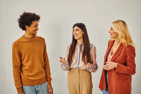 Three individuals engaging in conversation against a blank backdrop. — Stock Photo