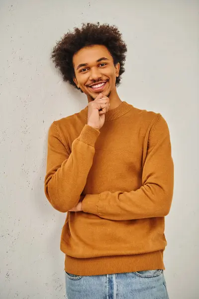Ein Mann im braunen Pullover lehnt an einer Wand. — Stockfoto