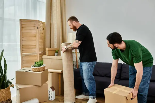 Um casal gay desempacota caixas em sua nova sala de estar, começando sua vida juntos em um novo capítulo promissor. — Fotografia de Stock