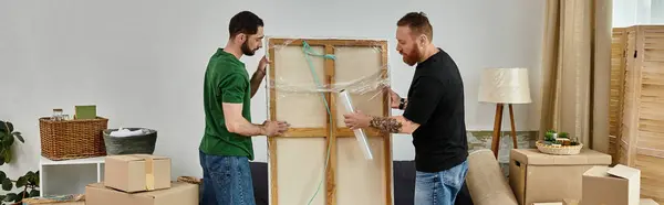 Deux hommes se tiennent l'un à côté de l'autre dans une pièce remplie de boîtes mobiles, commençant un nouveau chapitre ensemble — Photo de stock