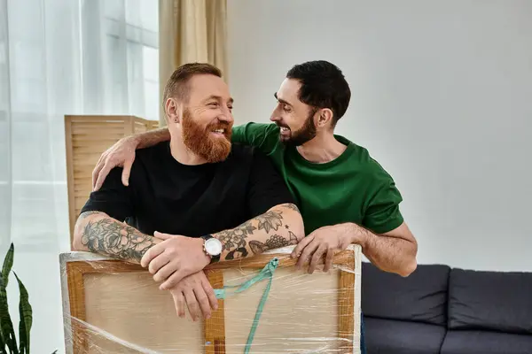 Ein verliebtes schwules Paar, nebeneinander sitzend, inmitten ihrer neuen Heimat in ein Gespräch vertieft — Stockfoto
