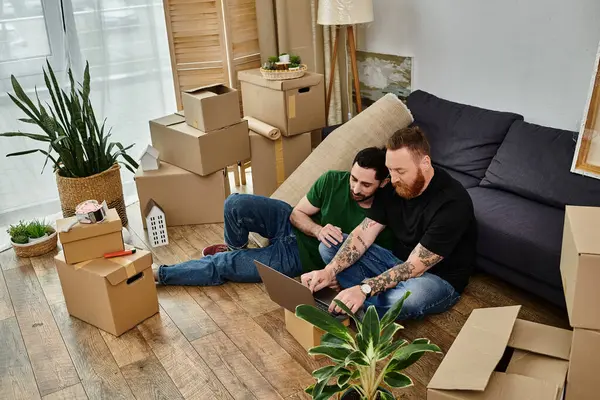 Двоє закоханих роблять перерву на дивані в новому будинку, заповненому коробками для переселення. — стокове фото