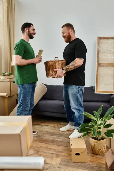Um casal gay explorando sua nova sala de estar cercada por caixas embaladas, começando um novo capítulo juntos. — Fotografia de Stock