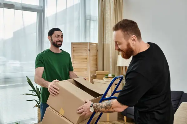 Ein verliebtes schwules Paar beim Auspacken von Kartons in seinem neuen Zuhause, symbolisiert Umzug und Neuanfang. — Stockfoto