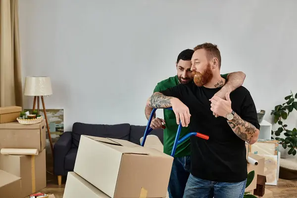 Two men, a gay couple, stand together in their new living room surrounded by moving boxes, embracing a fresh start. — Stock Photo