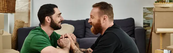 A gay couple holding hands in their new home, embracing their new life together. — Stock Photo