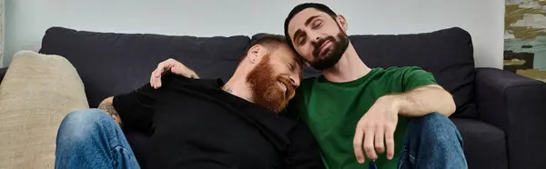 Couple of men chilling atop sleek couch, embracing new chapter in cozy setting. — Stock Photo