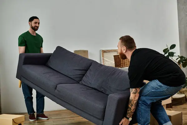 Gay couple happily moves sofa in new living room, starting fresh in new home. — Stock Photo