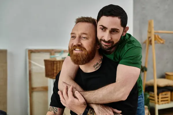 Two men embrace each other warmly in a room, symbolizing a new chapter in their lives together. — Stock Photo