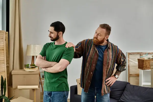 A gay couple having disagreement and misunderstanding while stand in their new living room — Stock Photo