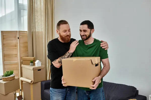 Gay casal de pé juntos no sala de estar cercado por mover caixas, começando fresco no novo casa. — Fotografia de Stock