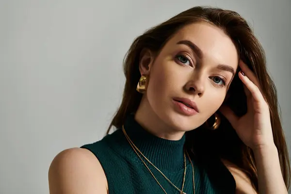 A woman in a green top is holding her hand to her ear, as if listening closely — Stock Photo