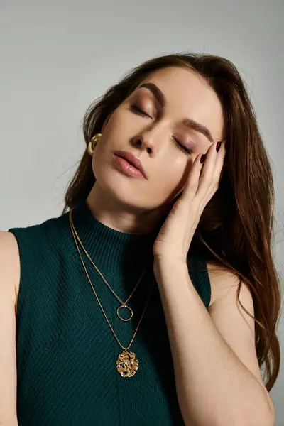 A young woman in a green top stands with her eyes closed in a moment of calm and reflection. — Stock Photo