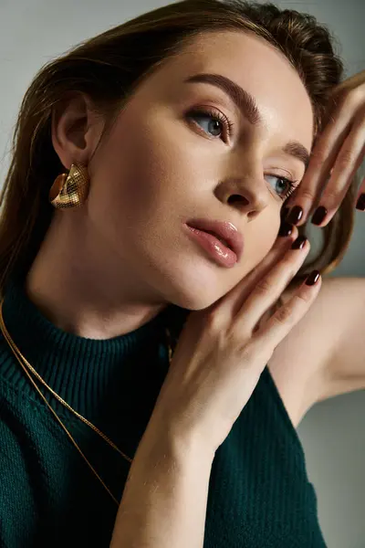 A young woman tenderly holds her hands to her face in a moment of thought and reflection. — Stock Photo