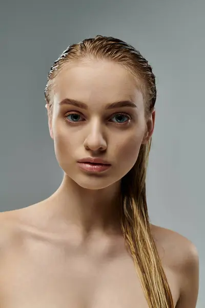 Alluring woman with long hair is gently touching her wet hair. — Stock Photo