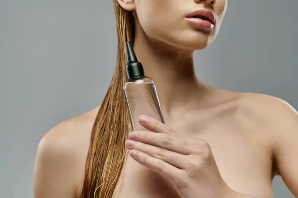 Привлекательная женщина с мокрыми волосами с помощью ухода за волосами. — стоковое фото