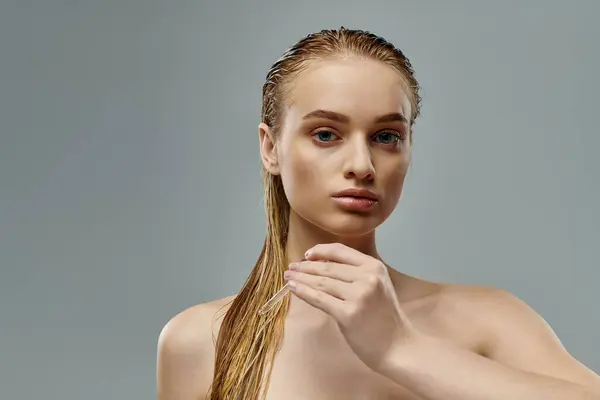Uma jovem, bela mulher mostrando sua rotina de cuidados com o cabelo com cabelos molhados e longos fluindo graciosamente. — Fotografia de Stock