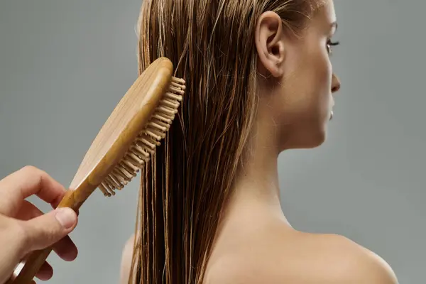 Eine junge schöne Frau streicht sich zart ihre nassen Haare. — Stockfoto