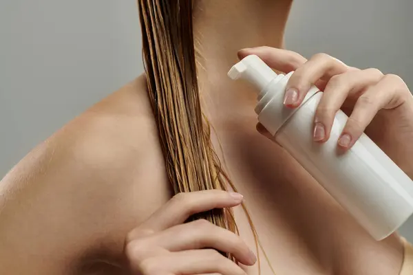 Young woman applying hair treatment. — Stock Photo