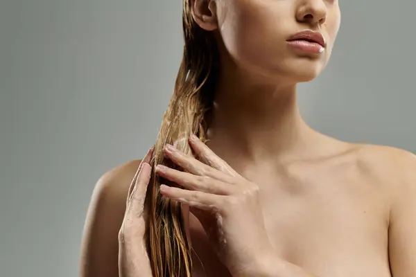 Woman with long hair tenderly applying hair care products. — Stockfoto