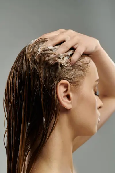 Donna seducente che applica prodotti per la cura dei capelli e lavaggio dei capelli. — Foto stock
