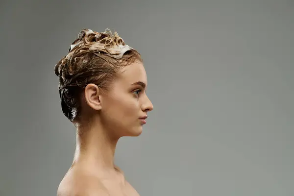 Jolie femme appliquant un produit de soins capillaires et lavant les cheveux. — Photo de stock