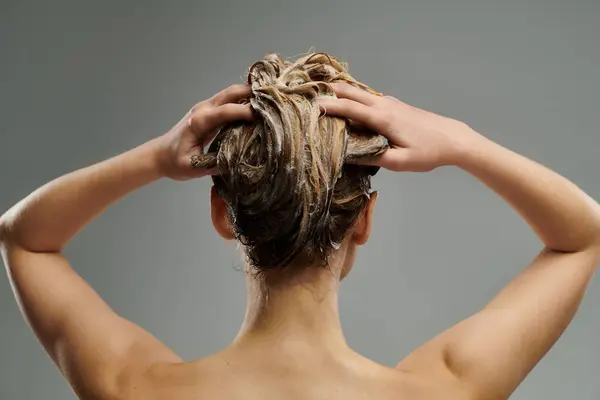 Une jeune femme démontre sa routine de soins capillaires avec des cheveux mouillés. — Photo de stock