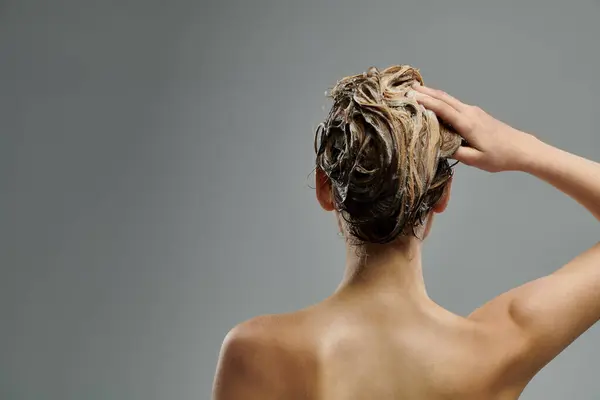 Eine junge Frau mit voluminösem Haar präsentiert ihre Haarpflege-Routine mit nassen Locken. — Stockfoto