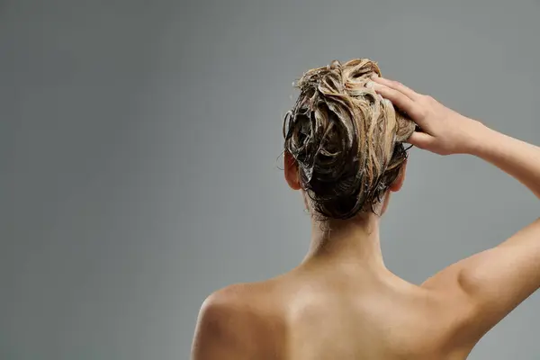 A young woman with voluminous hair showcases her hair care routine with wet locks. — Stock Photo