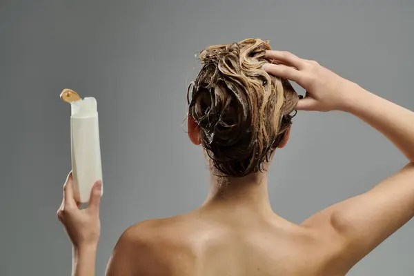 Woman holding a tube of shampoo. — Foto stock