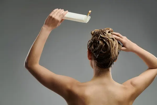 Schöne Frau hält eine Tube Shampoo. — Stockfoto