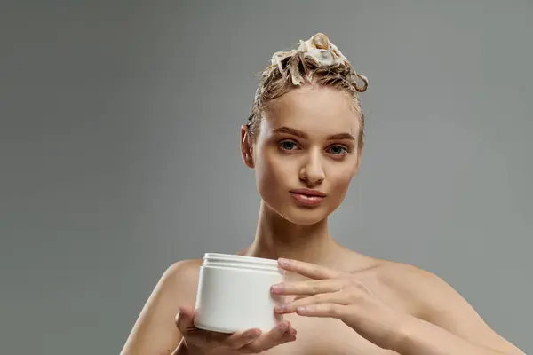Attractive woman holding a jar of hair mask. — Stock Photo