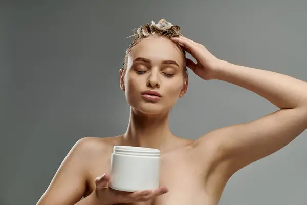 Alluring woman holding a jar of hair mask. — Stock Photo
