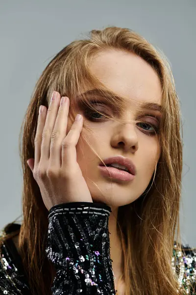 A woman with long hair gently touches her face. — Stock Photo