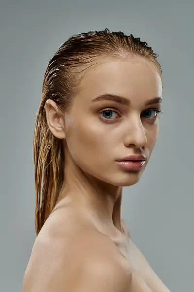Schöne Frau posiert mit nassen Haaren vor grauem Hintergrund. — Stockfoto