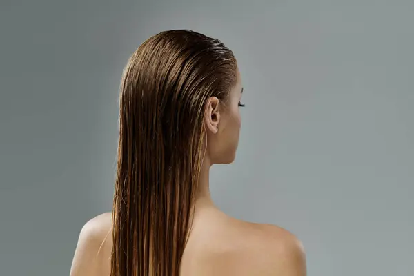 Eine Frau enthüllt ihre langen, nassen Haare. — Stockfoto