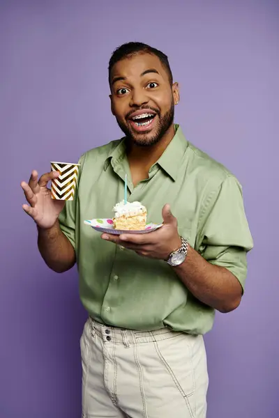 Junger afroamerikanischer Mann mit Zahnspange lächelt, während er einen Teller mit einem leckeren Stück Kuchen in der Hand hält. — Stockfoto