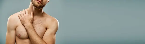 A shirtless, bearded man standing confidently with his hands placed on his chest in a studio setting. — Stock Photo