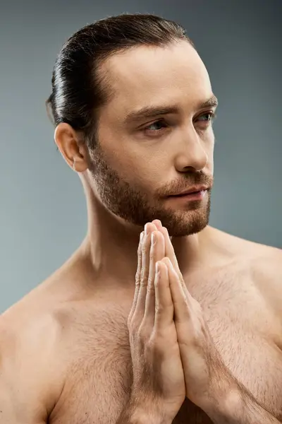 A shirtless, bearded man stands with his hands together, exuding a sense of peace and contemplation in a studio setting. — Stock Photo